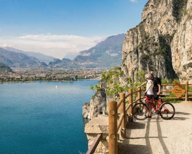 Cyclists admire the panorama from the Ponale trail in Riva del Garda, Italy.
